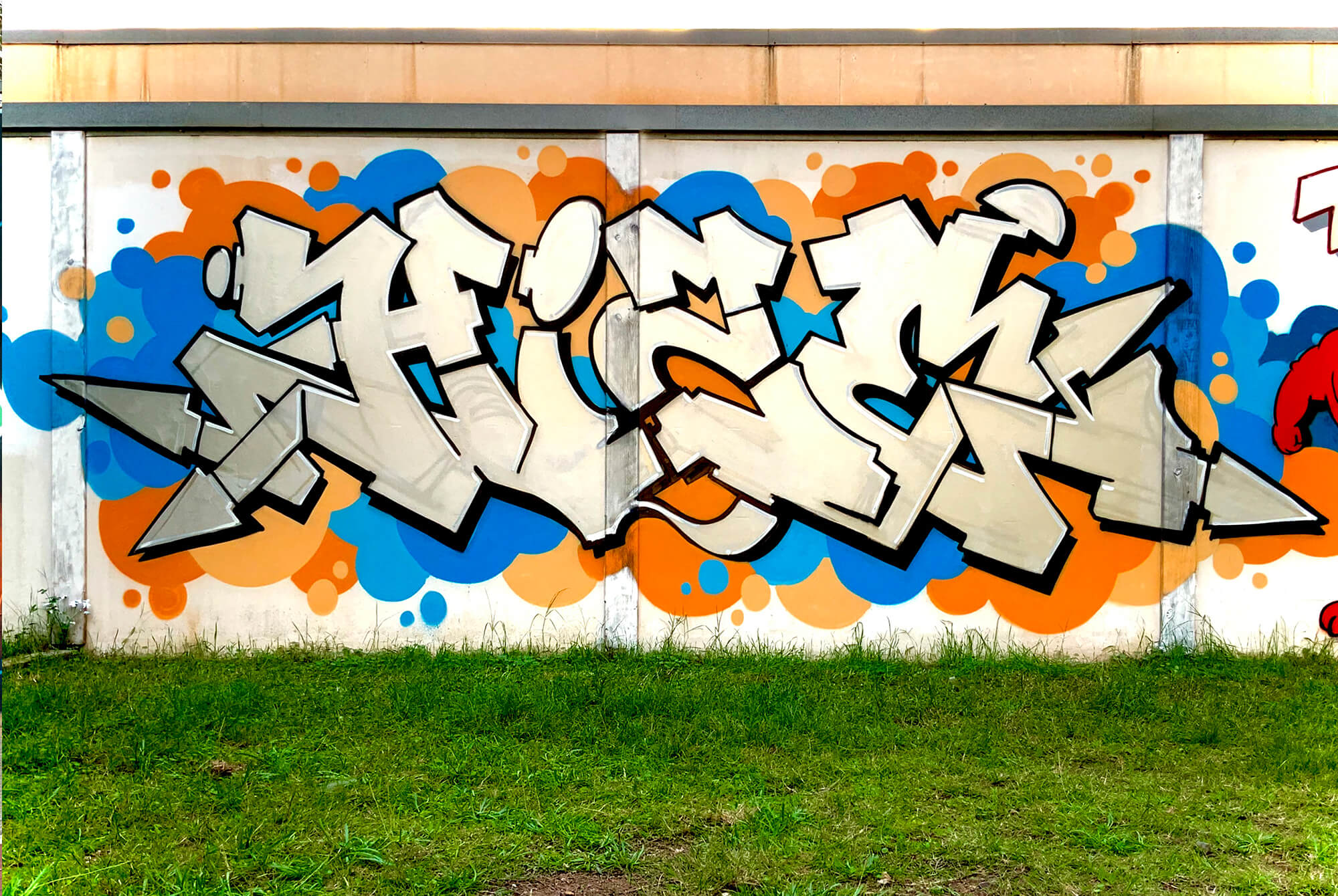Hize graffiti mural with silver lettering and orange blue bubble background