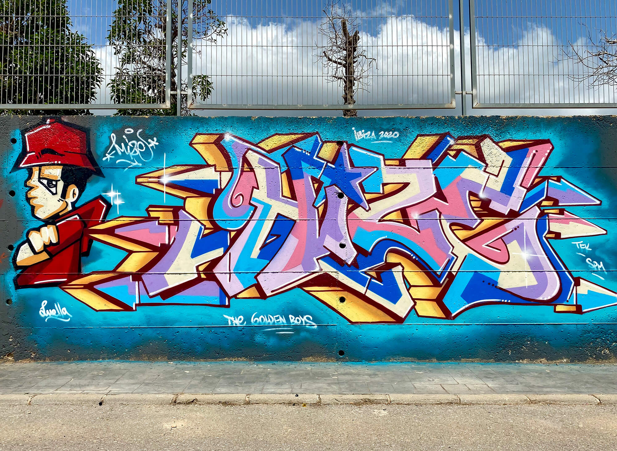 Hize Ibiza graffiti mural with pastel blue and pink wildstyle letters and red character